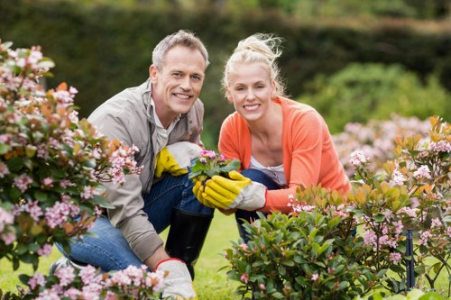 Workers separating green waste and recyclables in a residential garden